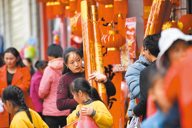 防疫當下，大陸多地籲民眾春節不返鄉，圖為春節前夕民眾在雲南保山市龍陵縣市場購買過年商品。（中新社資料照片）