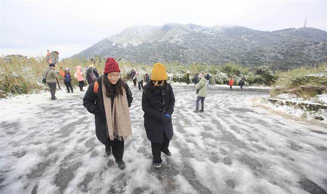 全台急冻，大台北地区大屯山持续飘下细雪，许多民眾纷纷穿上冬衣，衝上山赏雪。（张铠乙摄）