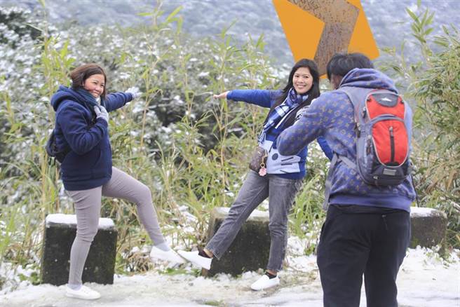 全台急凍，大台北地區大屯山持續飄下細雪，許多民眾紛紛穿上冬衣、開車衝上山並與雪景合影留念。（張鎧乙攝