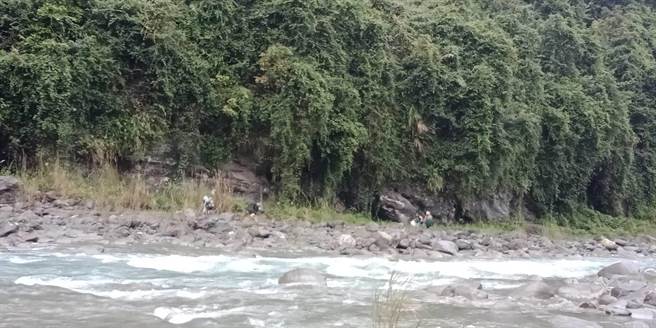 4名女性游客见溪水湍急且上涨至腰间，不敢随意渡河，受困在摩里沙卡温泉岩壁附近。（花莲县消防局提供／罗亦晽花莲传真）