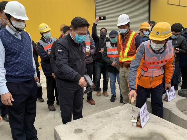 交通部长林佳龙（左二）视察「微创施工孔盖启闭创新工法」，特别拿起机器确认孔盖位置及其管线单位等资讯。（林欣仪摄）