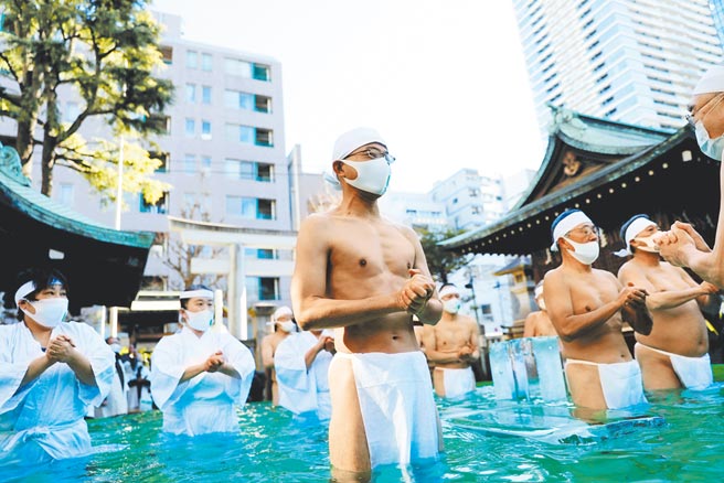 日本新冠疫情延烧，传统庆典上的表演者都戴上口罩，丝毫不敢大意。（路透）