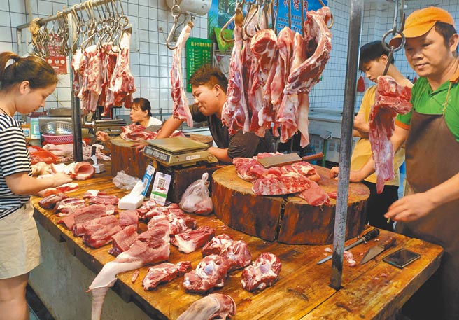 大陸豬肉價格連續7周上漲。圖為福建福州民眾在市場挑選豬肉。（中新社）