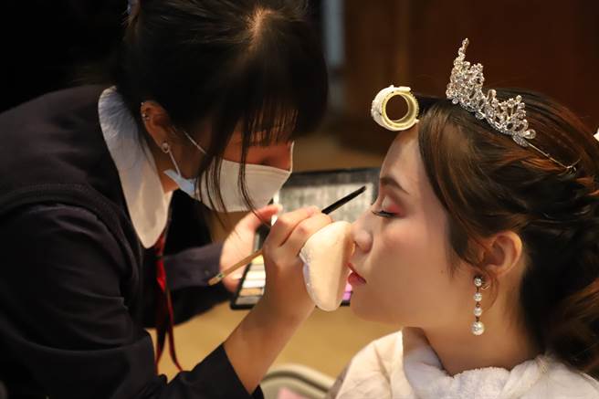 学生细心地为老师上妆，从中获益良多。（李宜杰摄）