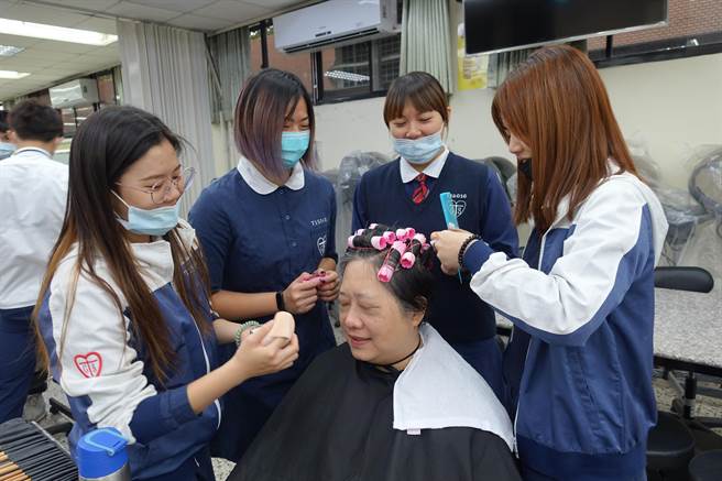 学生细心地为老师上妆，从中获益良多。（李宜杰摄）