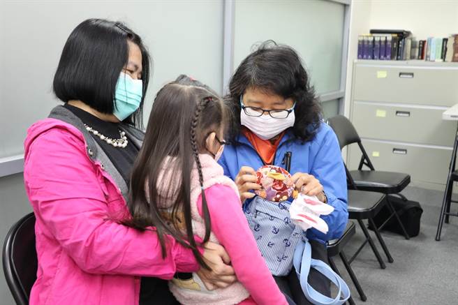 4岁的心心出养到澳洲 ，新北市家防中心主任许芝绮送上兔兔小钱包希望她能开心长大。（新北市社会局提供／叶德正新北传真）