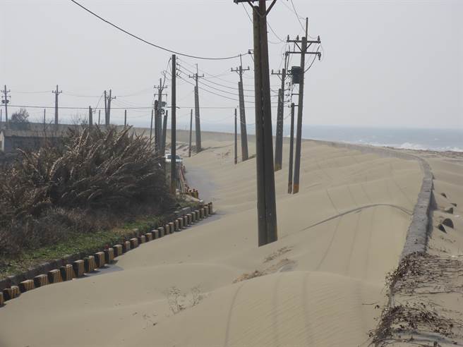 受到冬季风势影响，台南市北门海埔养殖专区出现沙丘漫过海堤的情形，连防汛道路都被遮盖，阻碍渔民人车通行，北门区公所及主管单位第五河川局已到场现勘，近期将调派机具抢通。（庄曜聪摄）