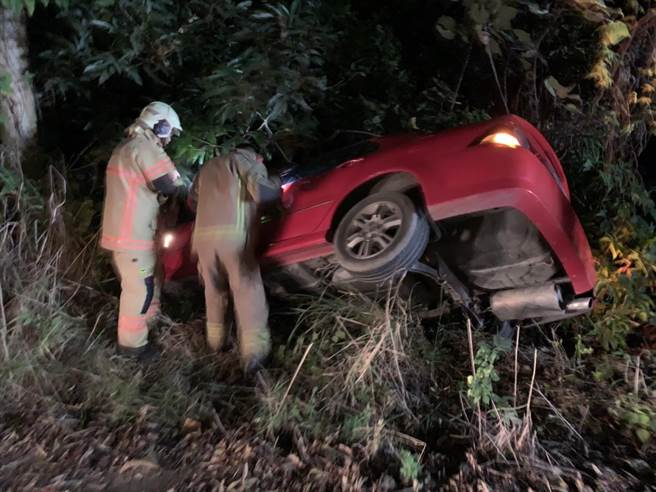 一輛轎車在台南新化山區衝出邊坡差點墜谷，警消到場時駕駛已經落跑，消防人員將女乘客救出，幸運並無受傷。（讀者提供／莊曜聰台南傳真）