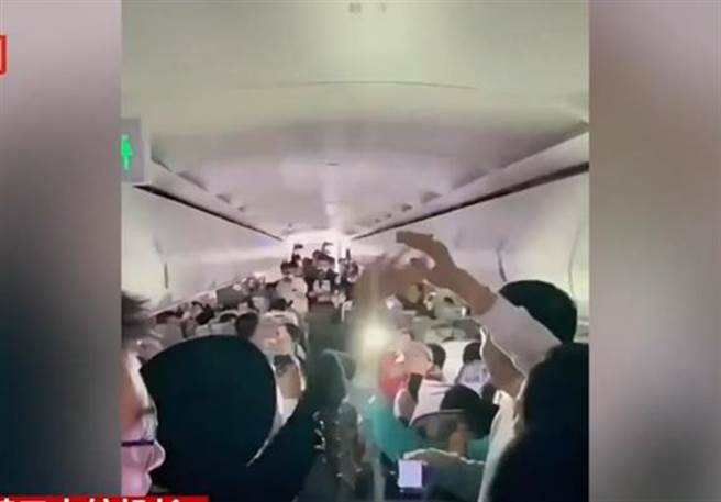 机舱灯光转暗乘客拿出手机随音乐挥舞（翻摄 界面新闻）