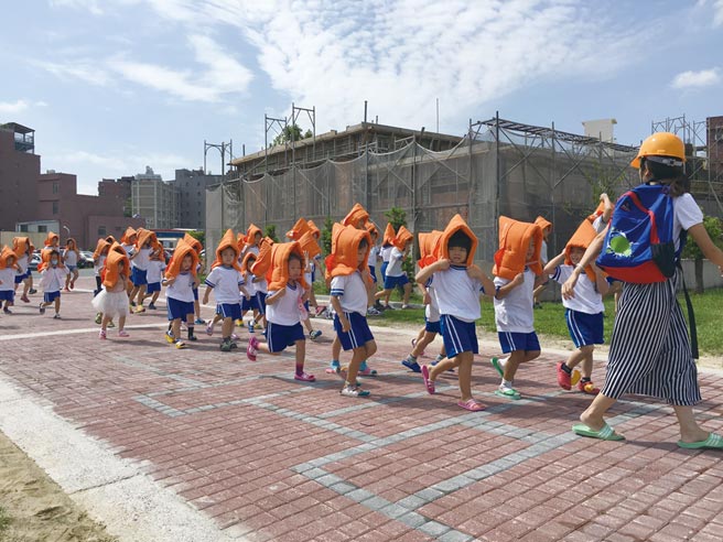 小學生們在老師引導下，戴上防震頭套演練地震逃生流程。圖／本報資料照片