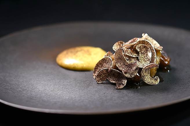 〈MUME〉冬季套餐中的〈鲍鱼／波特菇／焦化奶油〉，是将鲍鱼以「盐焗」概念在昆布盐上蒸烤至将熟，用波特菇与大蒜焦化奶油提味，上层再舖了以黑蒜粉提味的蘑菇片，形色味皆诱人。（图／姚舜）