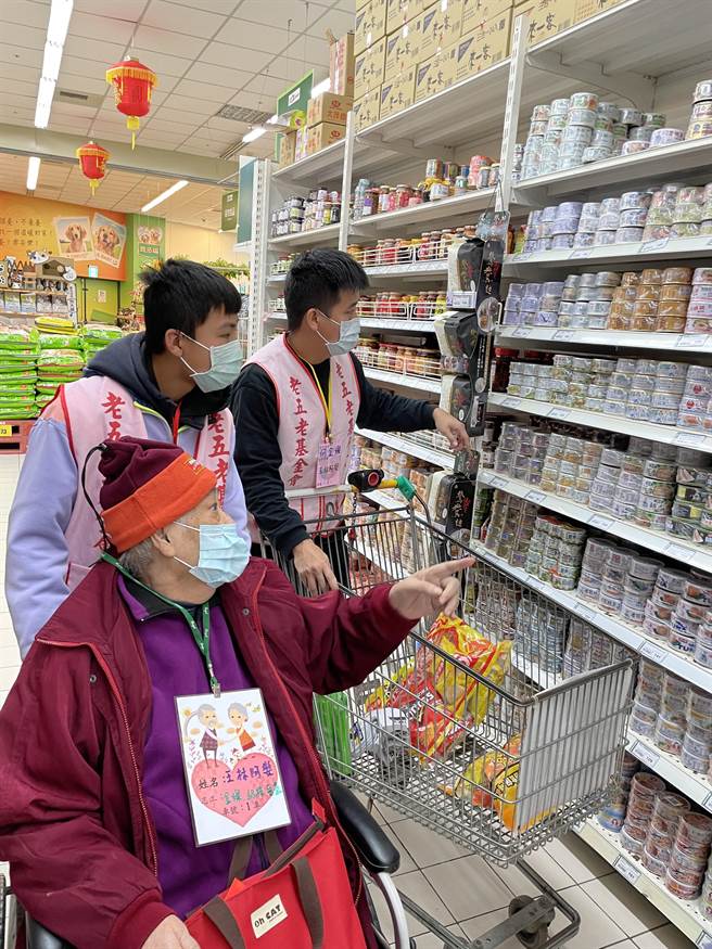 石冈国中14位学生推着坐轮椅的独居长辈逛卖场採买。（王文吉摄）