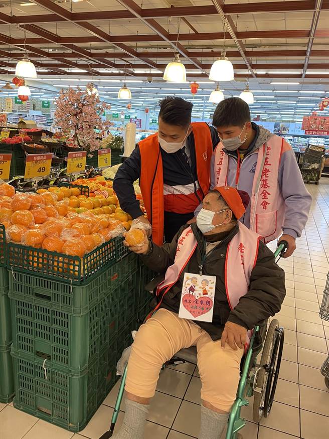 石冈国中14位学生推着坐轮椅的独居长辈逛卖场採买。（王文吉摄）