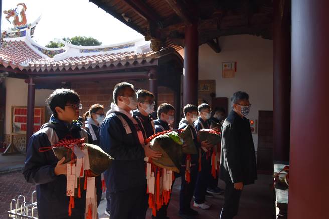 大甲高中校长萧建华带领高三师生代表，带着特制的大粽子前往大甲文昌祠拜拜祈愿。（王文吉摄）