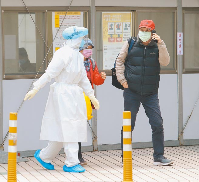 国内新增2名新冠肺炎本土个案，桃园某医院医师与女友染疫确诊，卫福部12日宣布不封院，採检站的医护人员穿着全套防护装备引导民眾。（陈怡诚摄）