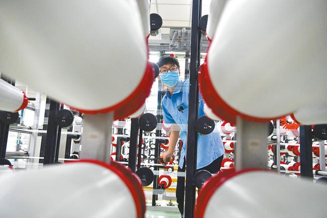 歷经疫情考验，台商藉此转型求生存。图为台企台嘉成都玻纤有限公司的工人戴着口罩作业。（中新社）