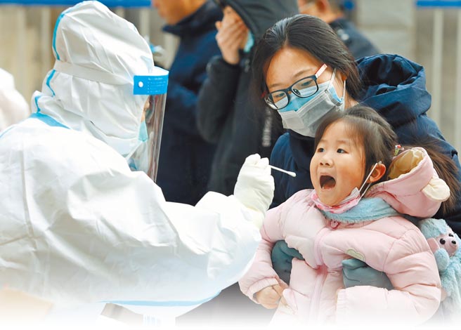 在大陆核酸检测已经走向商业化、市场化，电商平台京东、美团等纷纷涉足核酸检验服务，民眾可直接在手机下单。图为医护人员12日在石家庄市新华区锦绣乾城社区为一名儿童进行核酸採样。（新华社）