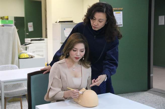 弘光科大妆品系副教授施佩缇(右)指导研究所学生蓝玉芳(左)参加OMC世界杯纹绣眉比赛。（陈淑娥摄）