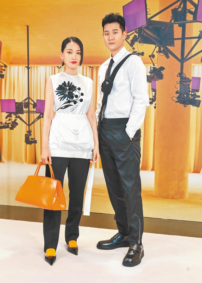 周兴哲（右）、林映唯合体穿Prada，大展高冷感。林穿白色印花无袖上衣7万1000元、Re-Nylon多功能短裙3万8500元、直筒长裤4万3500元、皮革梯型手提包11万元、三角标志单支耳环1万4000元、皮革拼色高跟鞋3万3500元；周穿口袋衬衫2万7500元、Nylon领带8400元、Re-Nylon西装长裤3万7500元、抛光皮革德比鞋3万3500元、Re-Nylon信差包5万1000元。（粘耿豪摄）
