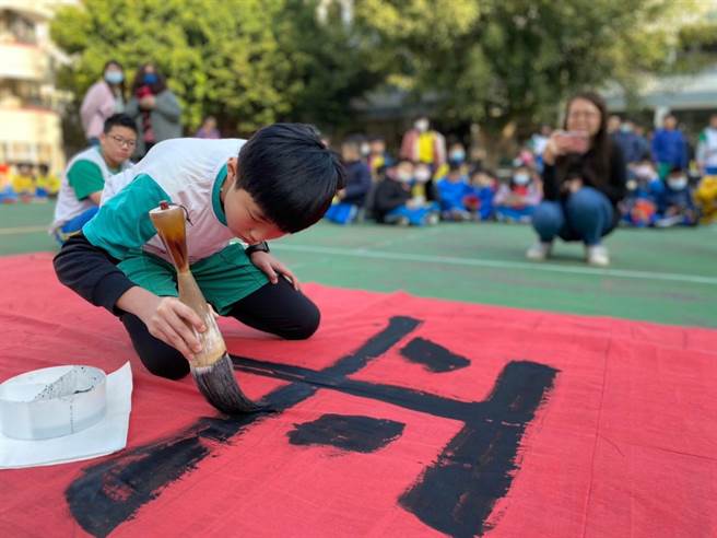 南屯学童展现书艺，启动牛年吉祥年画春联比赛，象徵「牛跃犁头，福耕南屯」的美好意象。（南屯国小提供）