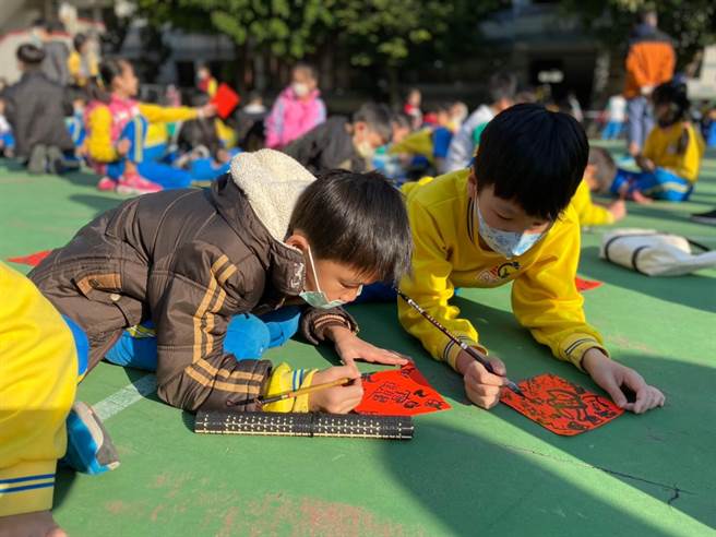 南屯学童展现书艺，启动牛年吉祥年画春联比赛，象徵「牛跃犁头，福耕南屯」的美好意象。（南屯国小提供）