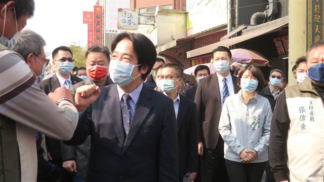 副总统赖清德下午亲临鹿港天后宫，庙方人员列队欢迎，防疫期间赖清德改以击手腕方式取代握手，与民眾打招呼。（谢琼云摄）