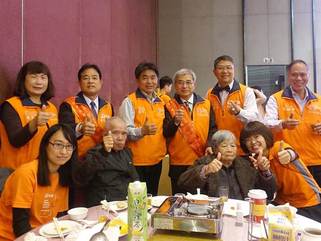 72歲身障的柯阿公(前排左2)第一次參加圍爐餐會，心情好、食慾大開。（謝瓊雲攝）