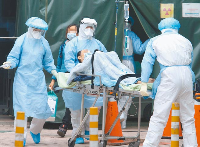 桃园某医院发生医护染疫事件，1名民眾前去急诊后，由身着防护设备的医护人员协助转院。(陈怡诚摄)