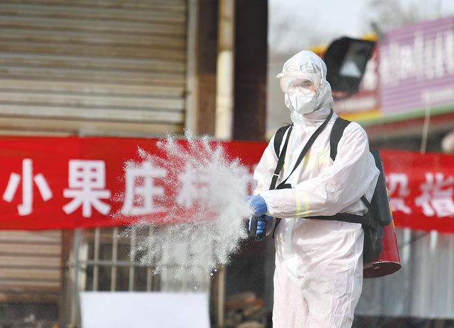 河北省石家庄疫情严重，当地防疫人员在小果庄村村口全面消毒。（中新社）