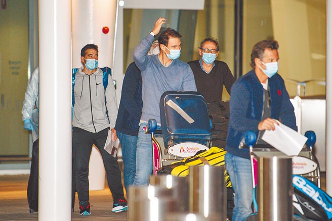 澳洲网球公开赛会内赛下个月开打，西班牙名将纳达尔（举手者）日前抵达墨尔本，因防疫需要先隔离14天。（美联社资料照片）