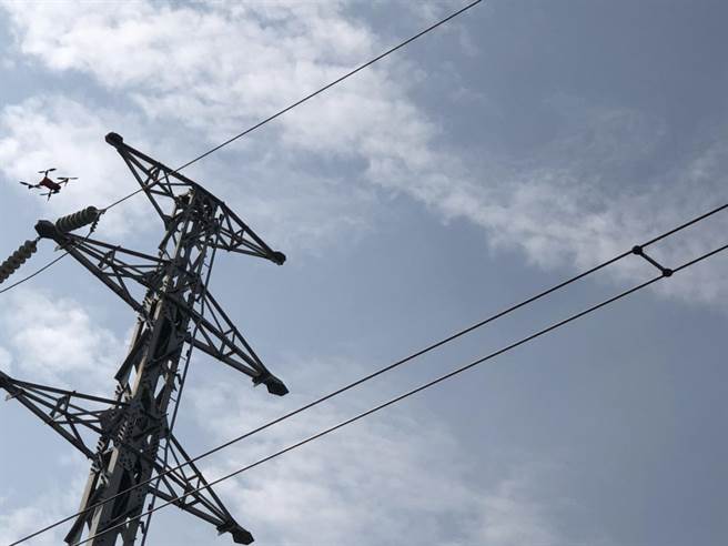 无人机飞到铁塔上，拍摄设备损坏照片并回传给维修人员。（图：王玉树摄）