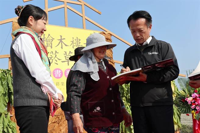 早期菸农（中）收到新书，兴奋地还请县长翁章梁（右）在上头帮她签名留念。（张毓翎摄）