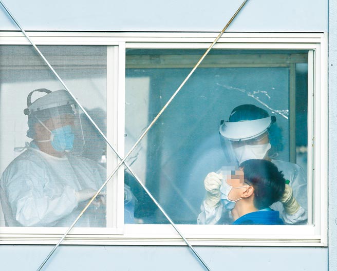 中央流行疫情指挥中心指挥官陈时中18日表示，部立桃园医院医护人员染疫再添一例，为同院护理师；上午该院防疫门诊出现民眾自费检疫，医护人员对检疫民眾採取检体。（陈怡诚摄）