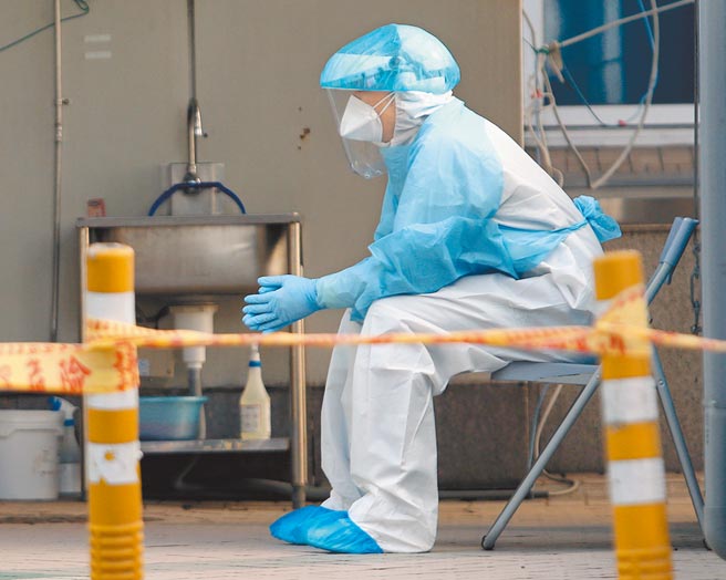 部立桃园医院爆发新冠肺炎院内群聚感染，中央流行疫情指挥中心已在院内设立「前进指挥所」，桃园医院急诊室外已围上警戒线防止民眾进入，1名身穿防护装备的医护人员在旁待命。（范扬光摄）