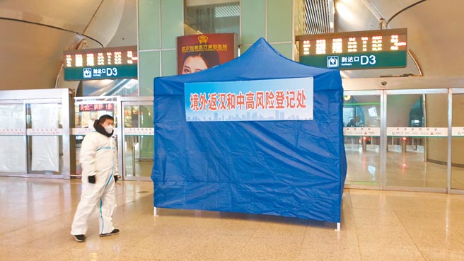 在武汉高铁站的出站口，安排了工作人员和各种标示牌，提醒来自新冠疫情中高风险地区的旅客登记个人资料。（蓝孝威摄）