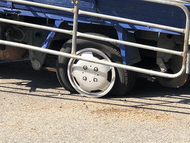小貨車的左後輪破胎，導致車輛失控撞到路燈桿。（李金生攝）