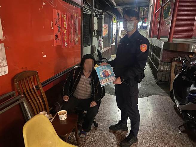 周员拿出宣导单，提醒街友注意保暖。（新庄警分局提供／李俊淇新北传真）