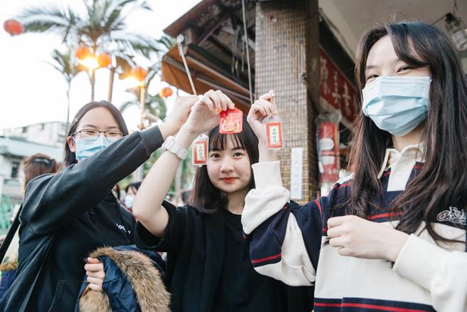 文昌宫涌现参拜人潮，几名考生秀出刚过香炉的金榜题名平安符。(郭吉铨摄)