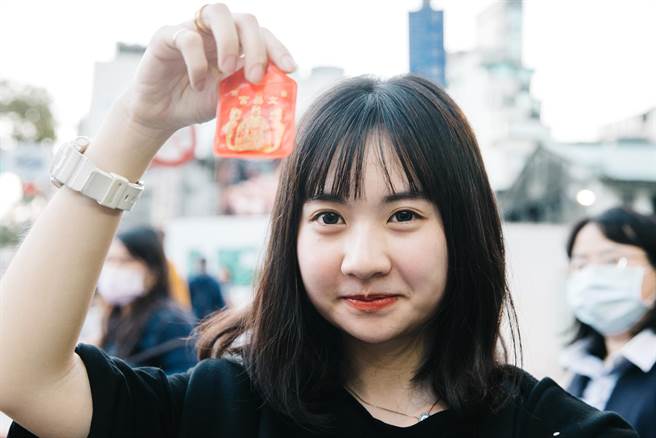 香火鼎盛的文昌宫涌现参拜人潮，一名考生秀出刚过香炉的金榜题名平安符。(郭吉铨摄)
