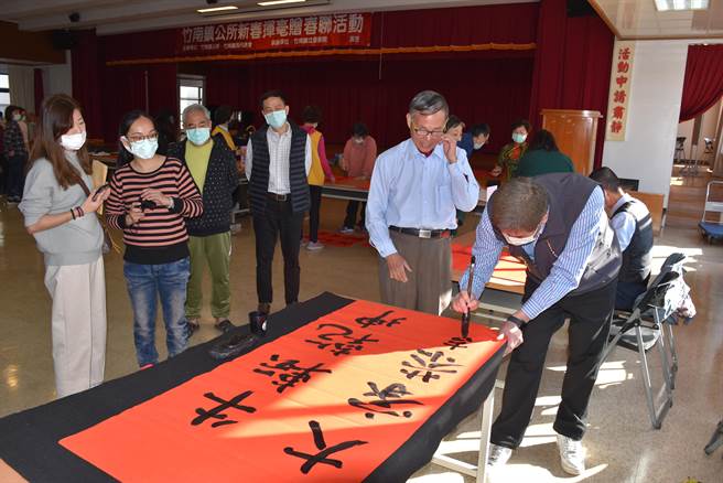 竹南镇方进兴当场挥毫写下「牛转乾坤  大家恭喜」来预祝镇民平安顺利。（谢明俊摄）