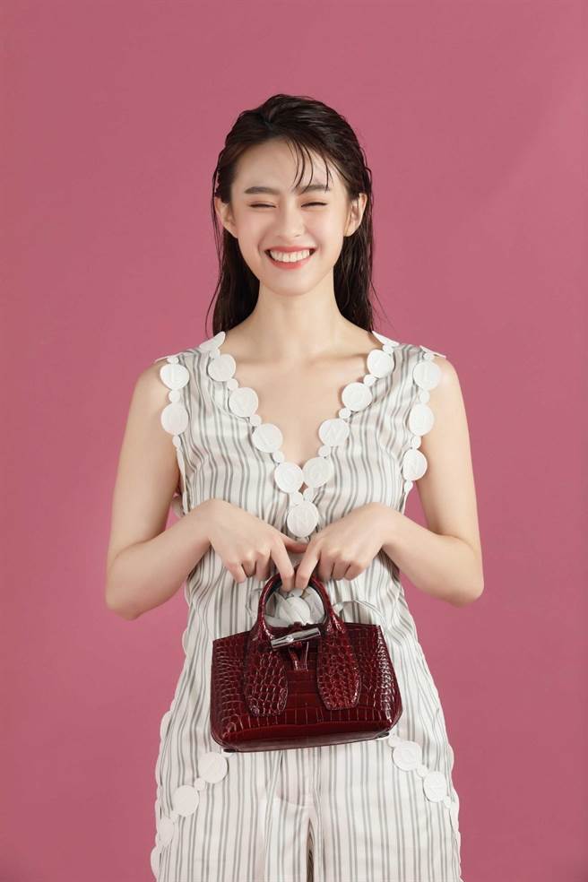 邱偲琹甜笑展现清新女孩风格，Longchamp 2021春夏服装系列 LOGO丝绸连衣裤，2万7100元，Roseau Croco 系列手提包 XS (酒红色)，1万7400元。（摄影 石智中）