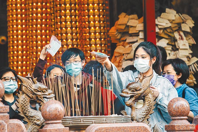 110学年度学科能力测验今天登场，香火鼎盛的台北市文昌宫昨日涌现前来参拜的人潮，碰上疫情，考生也不忘拿口罩过香炉，祈求试场上平安、顺利。（郭吉铨摄）