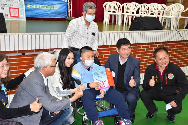 兴华高中国中部7年级的罗同学因罹患罕见疾病只能靠轿椅代步，锺东锦鼓励他未来成为小作家。（谢明俊摄）