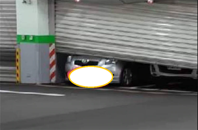 停车场铁门故障自动降下，正好压在准备出场的一部车子的车头上。（图／翻摄自脸书社团『新店好厝边』」

