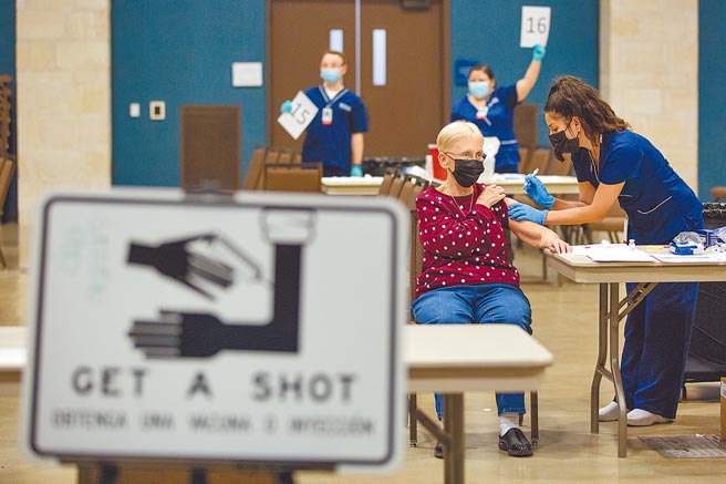 在美国德州一座大型疫苗接种中心内，护士21日为一名老妇人注射莫德纳（Moderna）新冠疫苗。美国已有超过40万人死于新冠肺炎，总统拜登上任后立刻快马加鞭展开抗疫行动。（美联社）