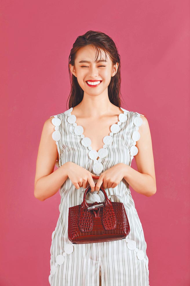 邱偲琹甜笑展现清新女孩风格，Longchamp 2021春夏服装系列 logo丝绸连衣裤2万7100元，Roseau Croco系列手提包XS（酒红色）1万7400元。（石智中摄）