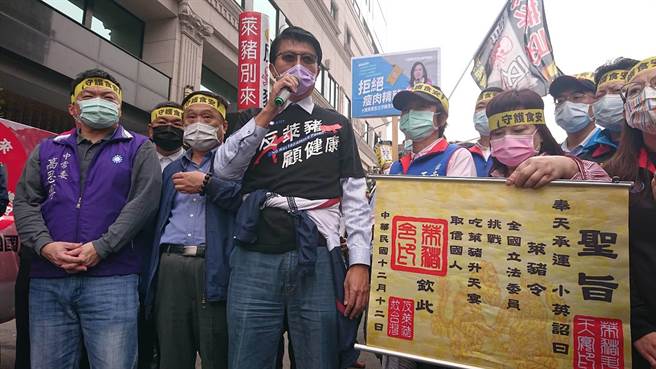 国民党副秘书长谢龙介（黑衣者）带头在菜市场前宣传反莱猪。（程炳璋摄）