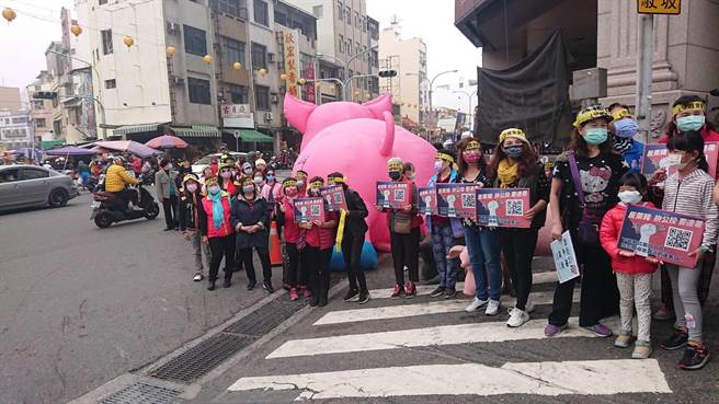 鸭母寮菜市场前民眾举牌高喊反莱猪。（程炳璋摄）
