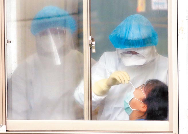 23日为武汉封城1周年，全球新冠肺炎疫情仍严重。图为桃园医院户外筛检室内，护理人员正为院内工作人员採检。（范扬光摄）