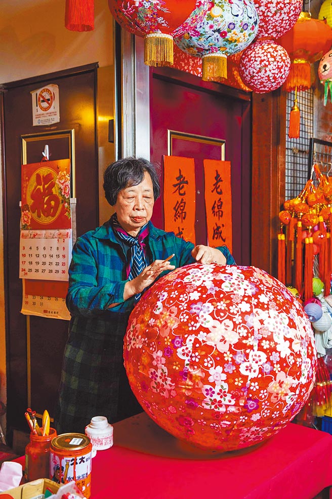 第3代负责人张美美在灯笼骨架上糊纸、上色、题字、上防水涂层等步骤不假他人之手。（石智中摄）